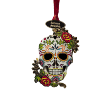 Colorful sugar skull ornament with floral designs, a red ribbon, and a tag reading Sedona, Arizona.