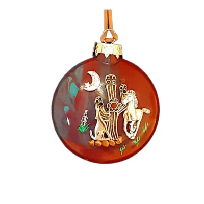Terracotta red and teal glass Southwest ornament featuring a silver saguaro cactus charm with flower blossom, howling wolf, wild horse, and crescent moon with star.