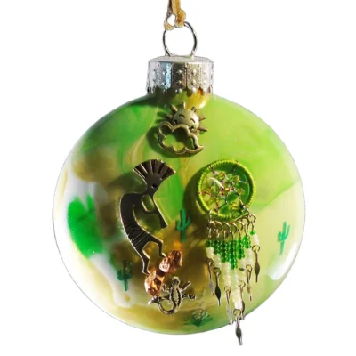 Alt Tag Green glass Southwest ornament featuring a silver Kokopelli, miniature lizard, green and white beaded dreamcatcher, and sun with cloud charm.