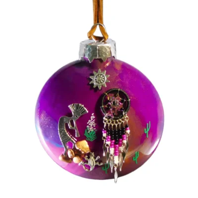 Purple glass Christmas ornament with desert-themed charms: a dreamcatcher, small seahorse, cacti, and beads hanging from a silver cap and brown string.