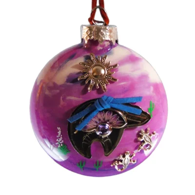 Alt Tag Purple and pink glass Southwest ornament featuring a black fetish bear charm with blue suede arrow wrapped around it, silver lizards, and sun emblem.
